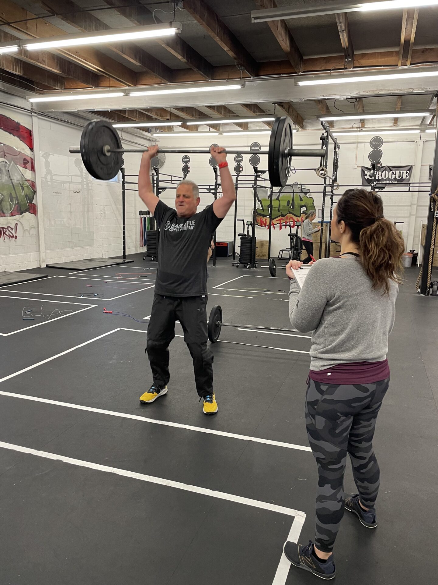 man in gyn training with personal trainer